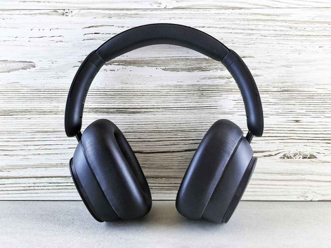 Black over-ear headphones on a wooden background.