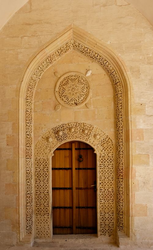 Free Beautiful carved stone archway with a wooden door in warm light. Stock Photo