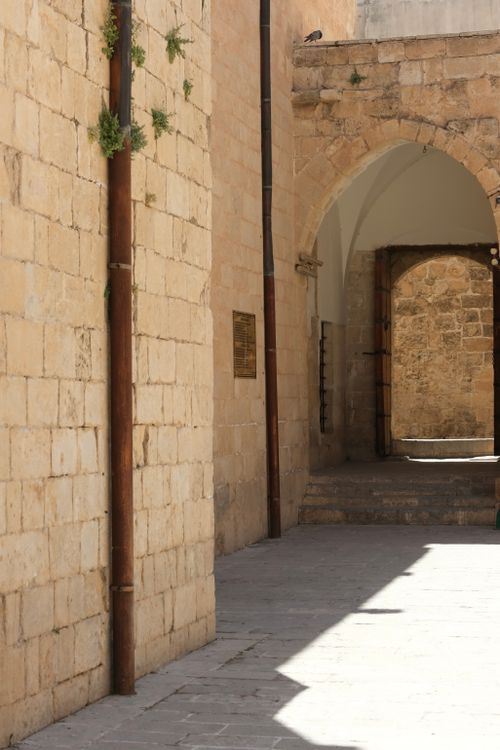 Free Sunlit stone alleyway with arches, showcasing historical architecture and serene solitude. Stock Photo