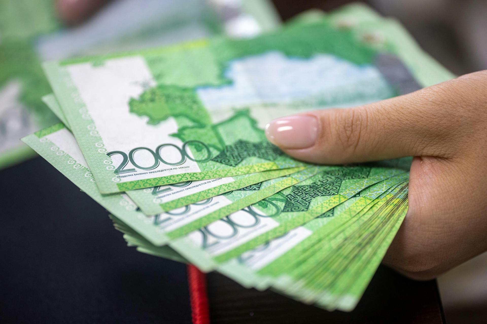 Close-up of a hand holding 2000 Russian Ruble banknotes, financial concept.