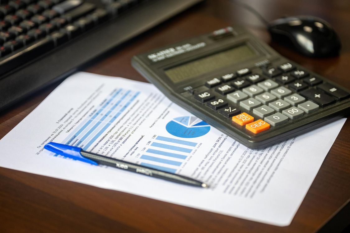 Calculator resting on a financial report next to a pen