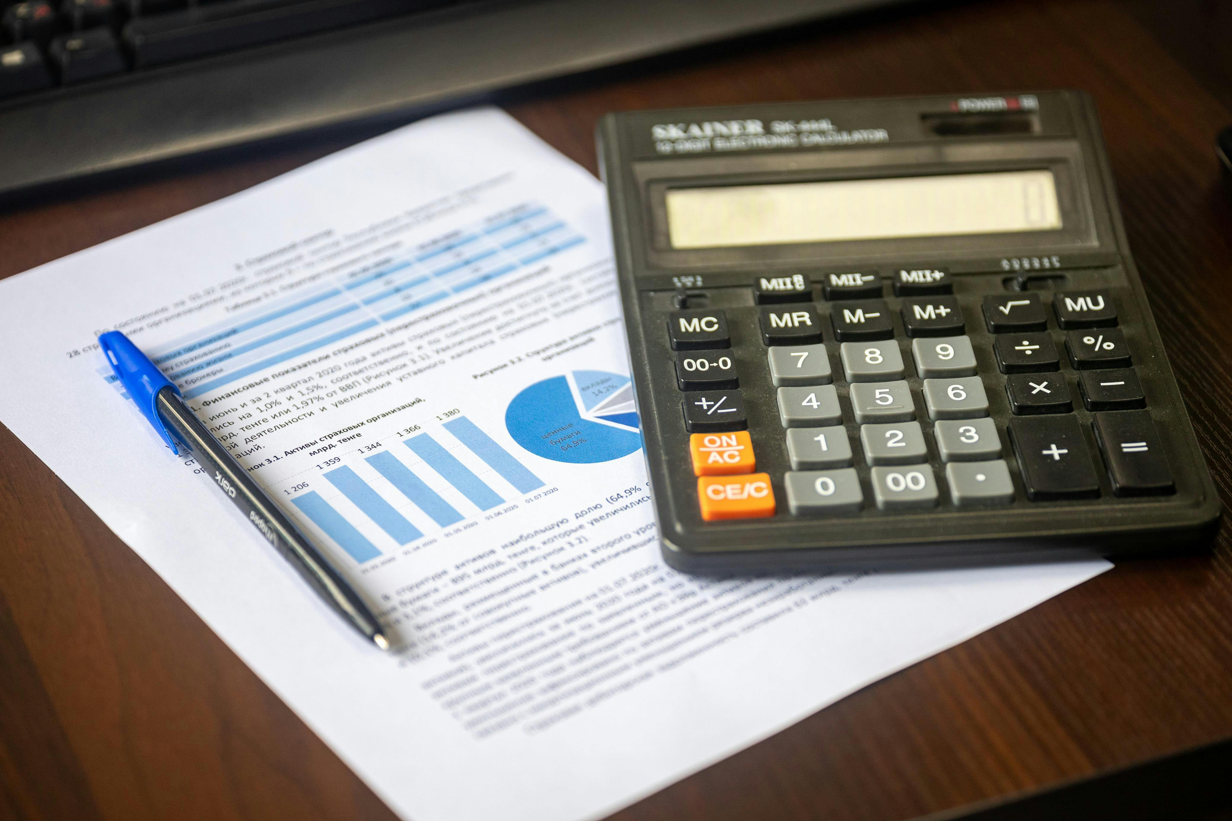 Calcolatrice e rapporto finanziario stampato in primo piano sulla scrivania
