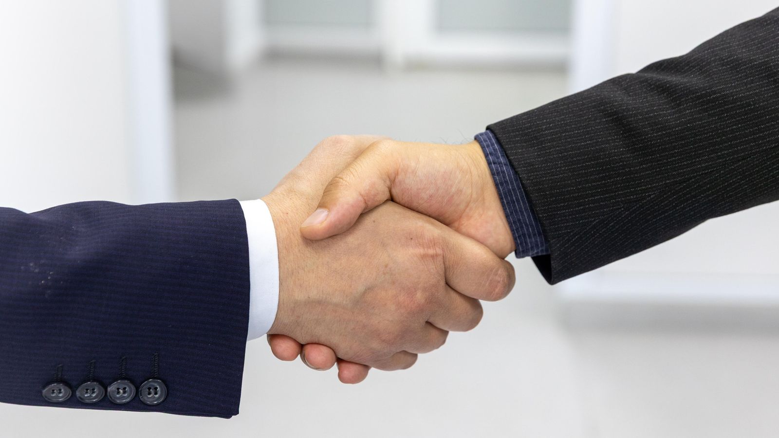 Close-up of a handshake in a business environment, symbolizing partnership.