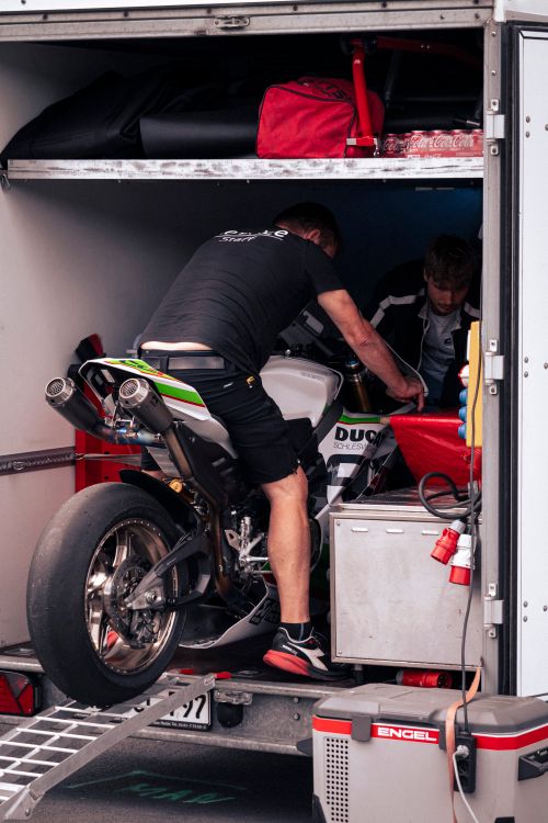 Free Technicians preparing a Ducati motorbike inside a trailer at Nürburgring racetrack, Germany. Stock Photo