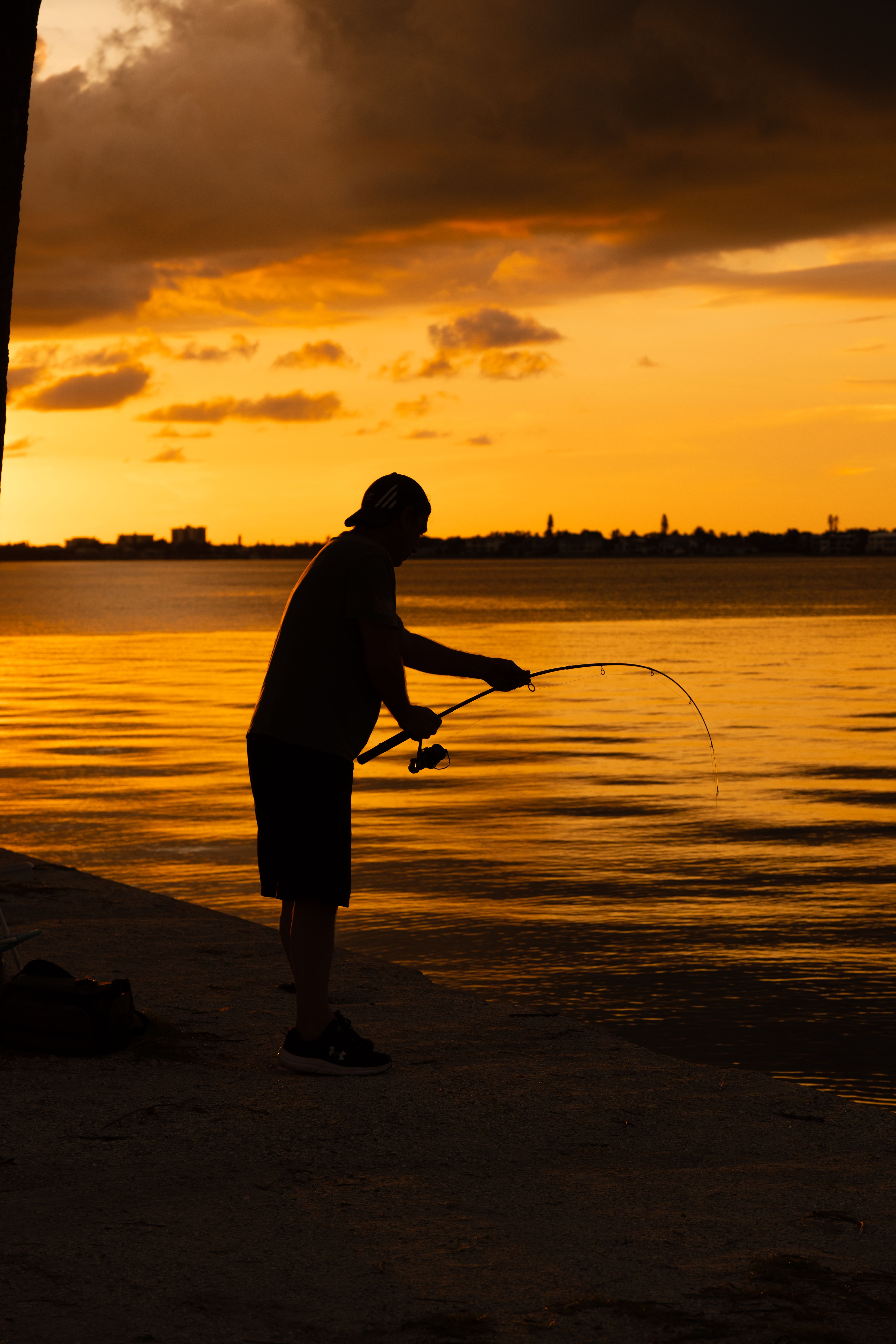 Silhouette of Man Fishing at Sunset by the Lake · Free Stock Photo
