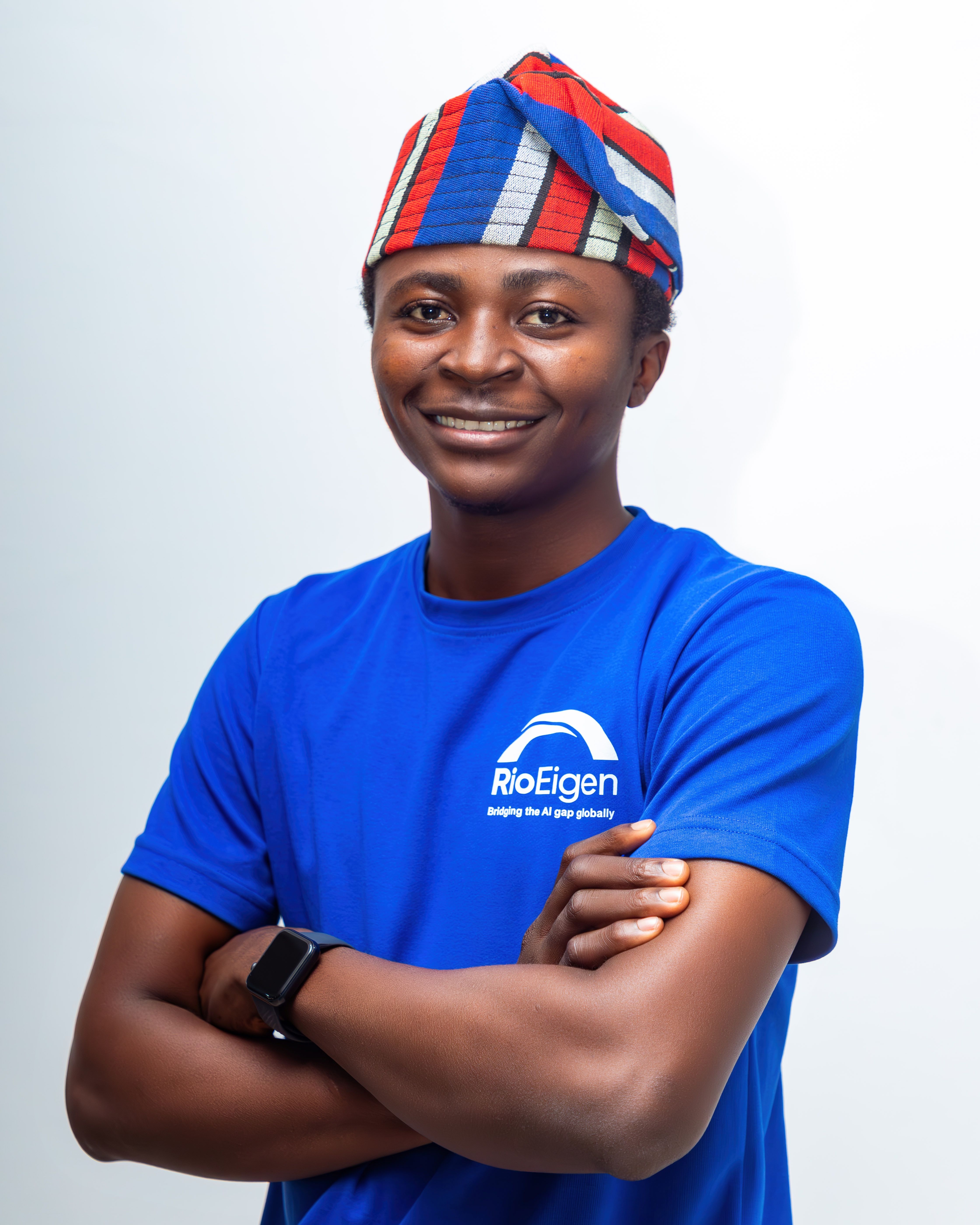 Person in a colorful traditional hat standing confidently with arms crossed.
