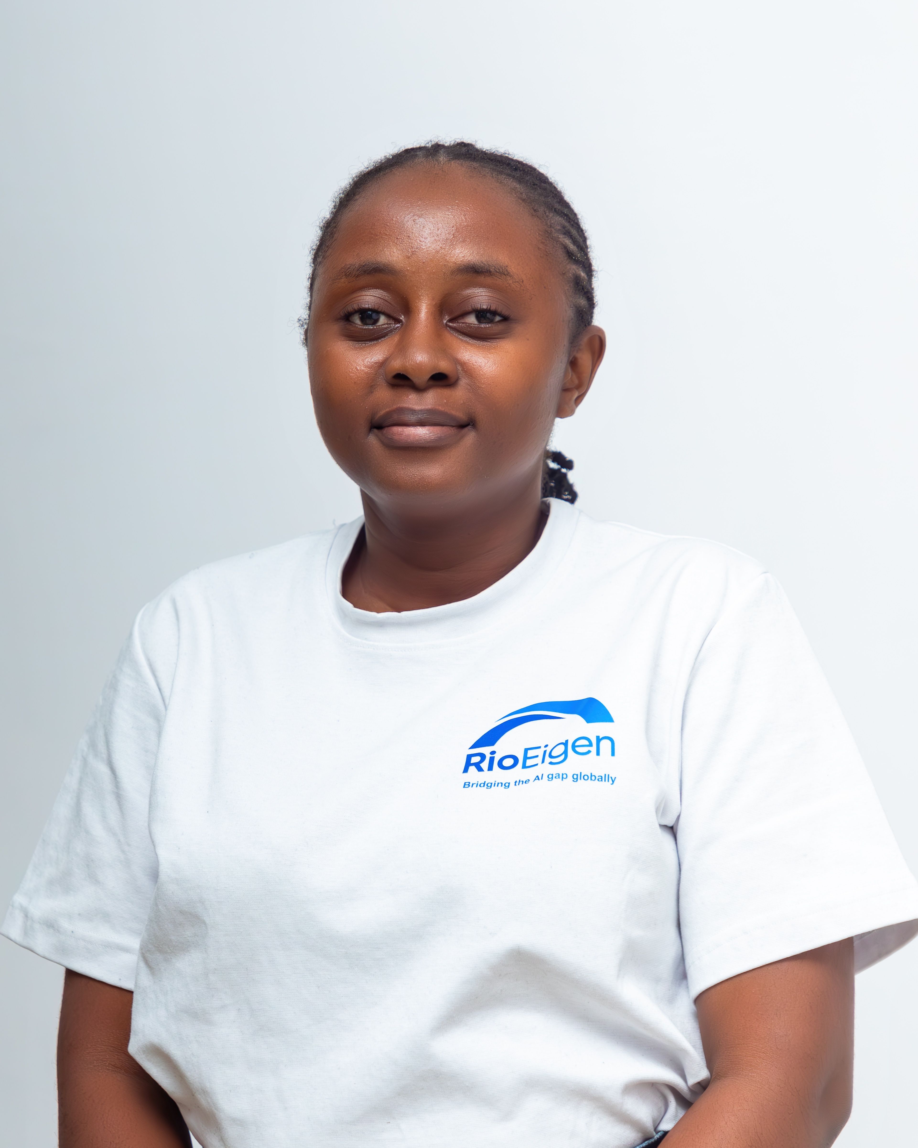 Smiling woman in a white t-shirt with 'RioEigen' logo on a plain background.