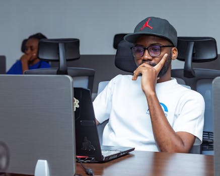 Young professional working intently on a laptop in a modern office setting. Ideal for business themes.