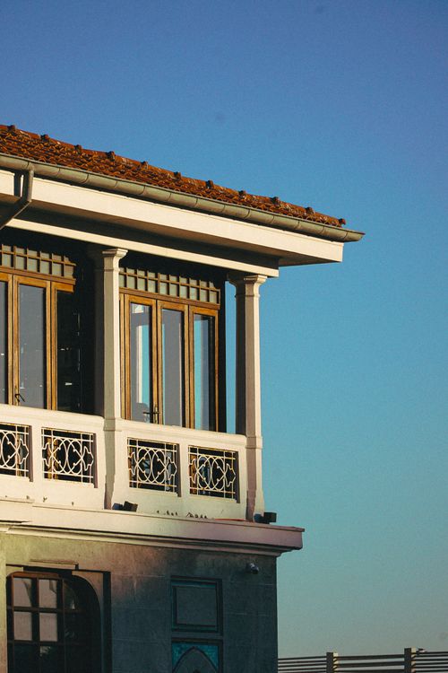 Free A stylish balcony with elaborate ironwork and warm sunlight on the facade. Stock Photo