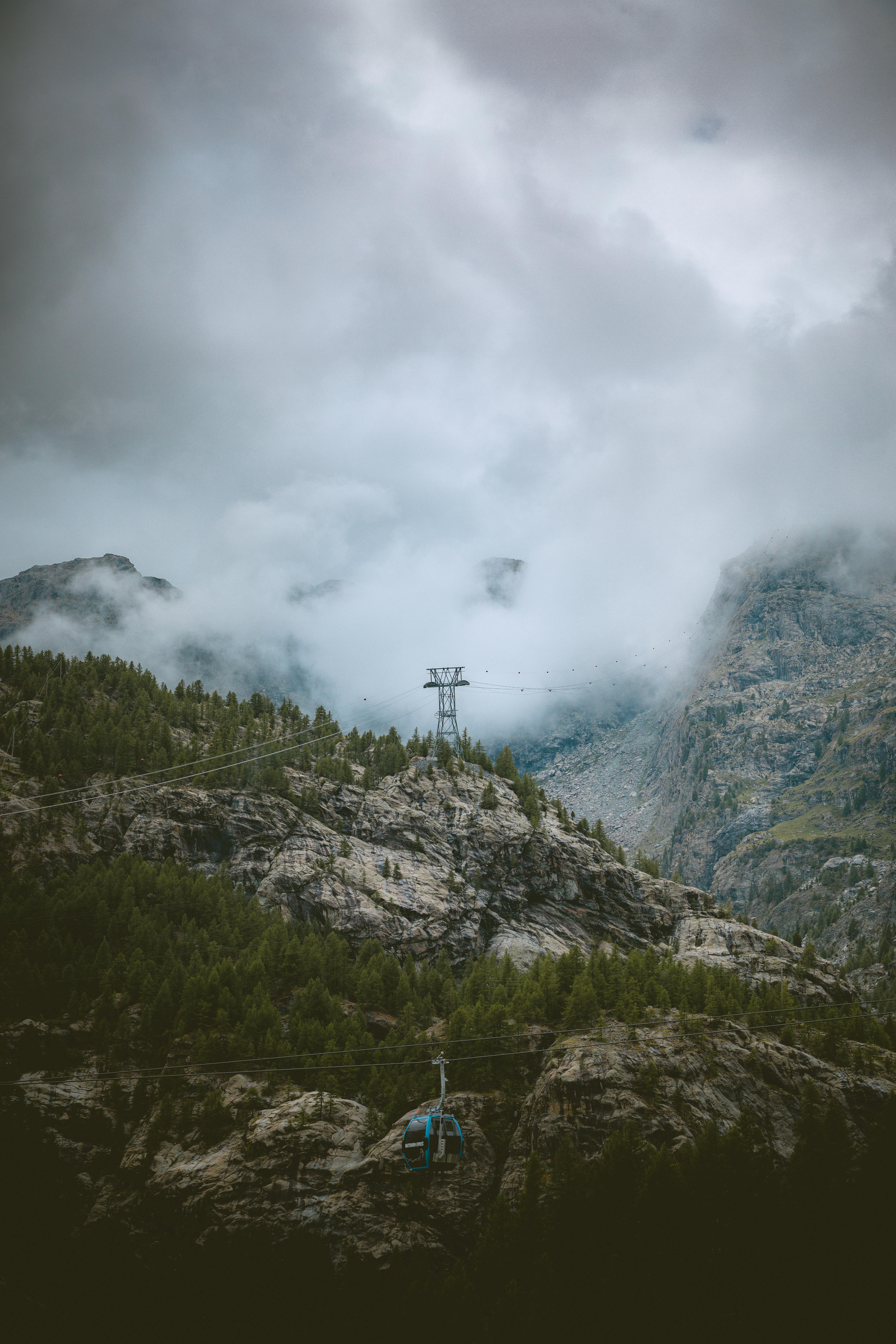 Foggy mountain landscape with a cable car near Zermatt, showcasing Swiss alpine beauty and dramatic scenery.