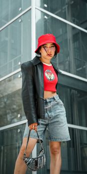 Stylish woman in red hat and casual outfit in an urban setting. Modern fashion portrait.