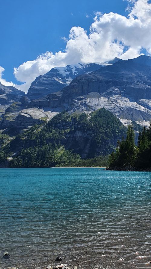 Free Breathtaking Swiss lake with turquoise water and majestic mountains under a clear sky. Stock Photo