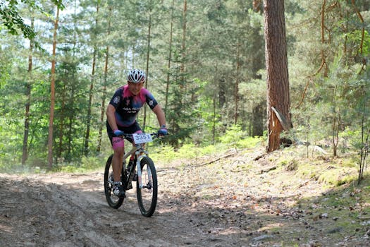 Ciclista di mountain bike in una foresta che partecipa a una gara ciclistica in una giornata di sole.