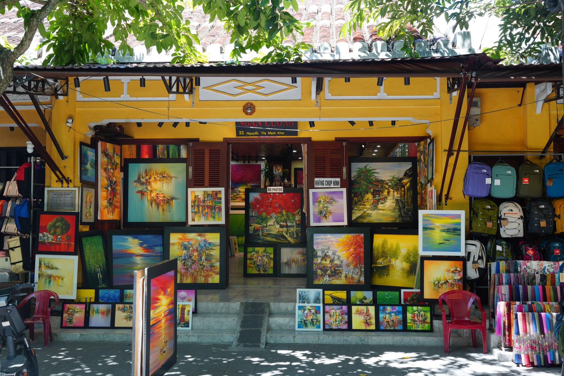 Vibrant artwork displayed at an outdoor street gallery under sunny skies.
