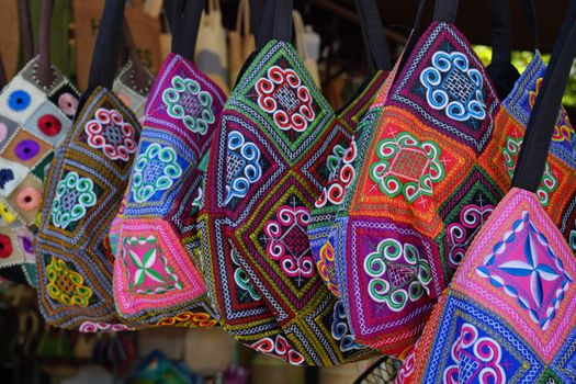 Colorful embroidered bags with traditional patterns on display.