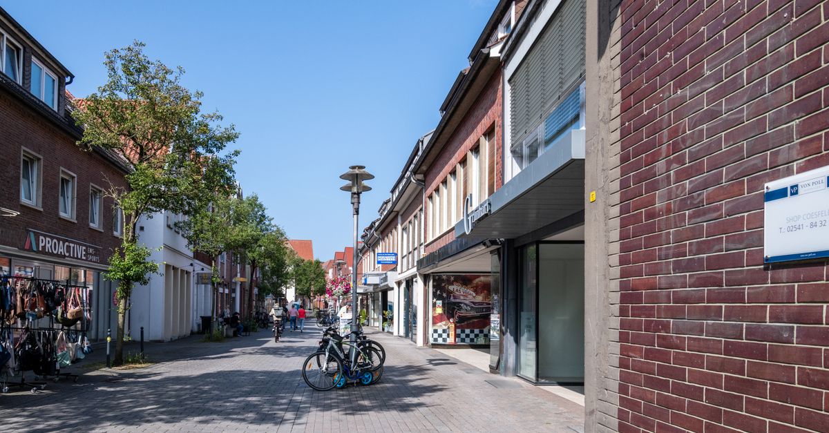 A vibrant street scene in a European town with bicycles and shops under a clear blue sky.
