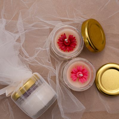 Poured floral candles in glass jars with gift wrap — photo by Susheel Parihar on Pexels