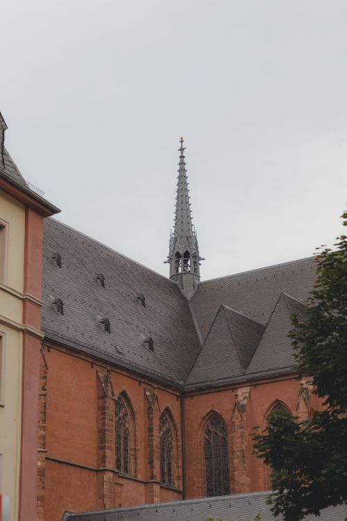 Free Majestic Gothic church architecture featuring a steeple on a cloudy day. Stock Photo