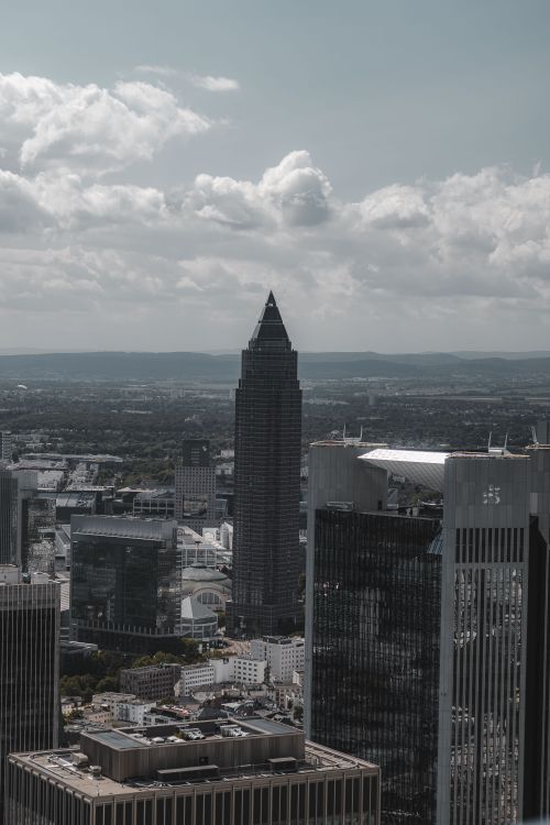 Free Aerial view of Frankfurt's skyline featuring the prominent Messeturm with cloudy sky. Stock Photo