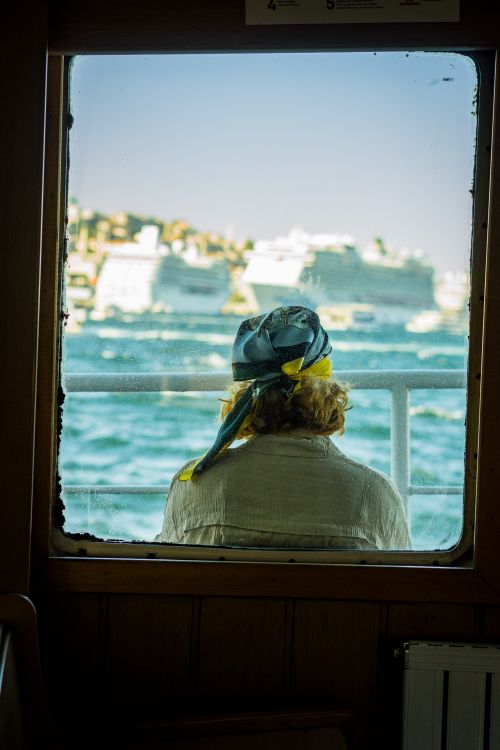 Free A person enjoys the view of cruise ships on a sunny day, seen through a boat window. Stock Photo