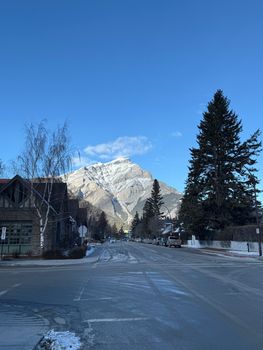 Beautiful winter view of a snow-capped mountain in Banff with a clear blue sky.