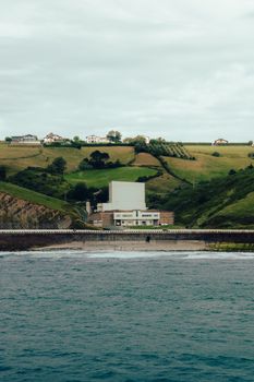 A scenic coastal view of Zumaia, País Vasco, Spain with rolling green hills and buildings.