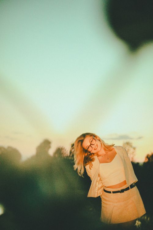 Young Woman Smiling Outdoors at Sunset · Free Stock Photo