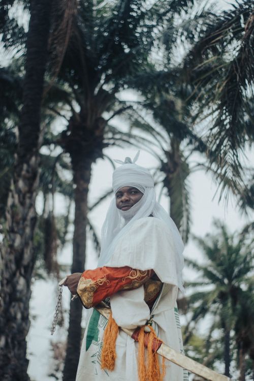 Free Man in traditional clothing amidst palm trees, reflecting cultural heritage. Stock Photo