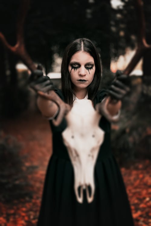 Woman in Black Dress Holding Animal Skull