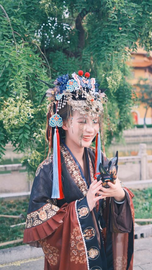 Free A joyful woman in ornate traditional attire poses in a lush outdoor setting. Stock Photo