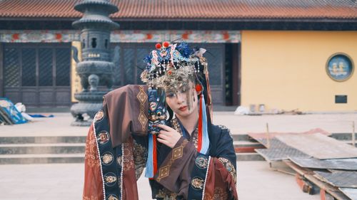 Free Person in ornate traditional costume and headpiece at an outdoor cultural setting. Stock Photo