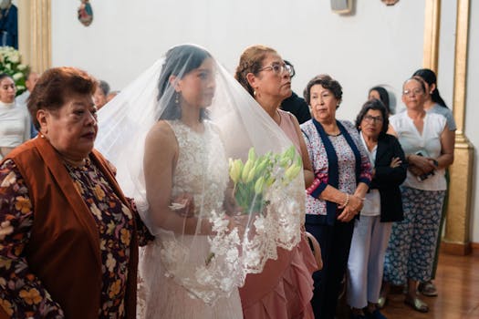 A bride walks down the aisle with family, holding flowers in a church setting.