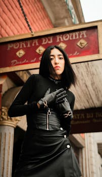 Stylish woman in black attire poses confidently at Porta di Roma.