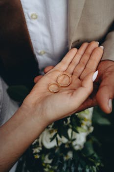 Intimate close-up of wedding rings held by the bride, capturing a beautiful moment.