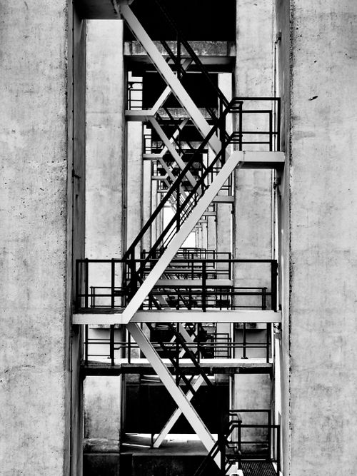 Free Artistic view of an industrial staircase in monochrome, showcasing geometric patterns. Stock Photo