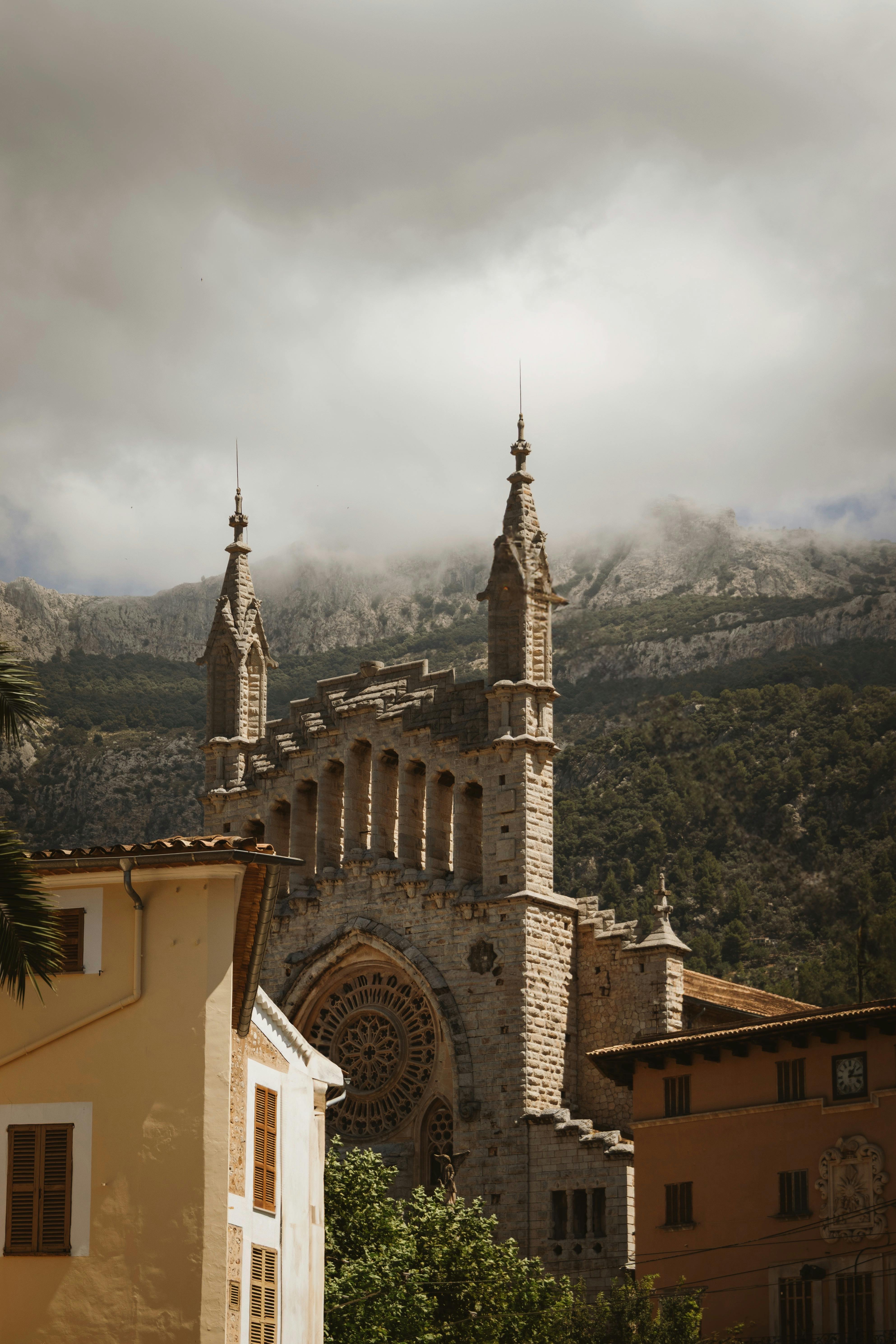 Beautiful Gothic cathedral in Sóller, Mallorca against dramatic mountain backdrop.