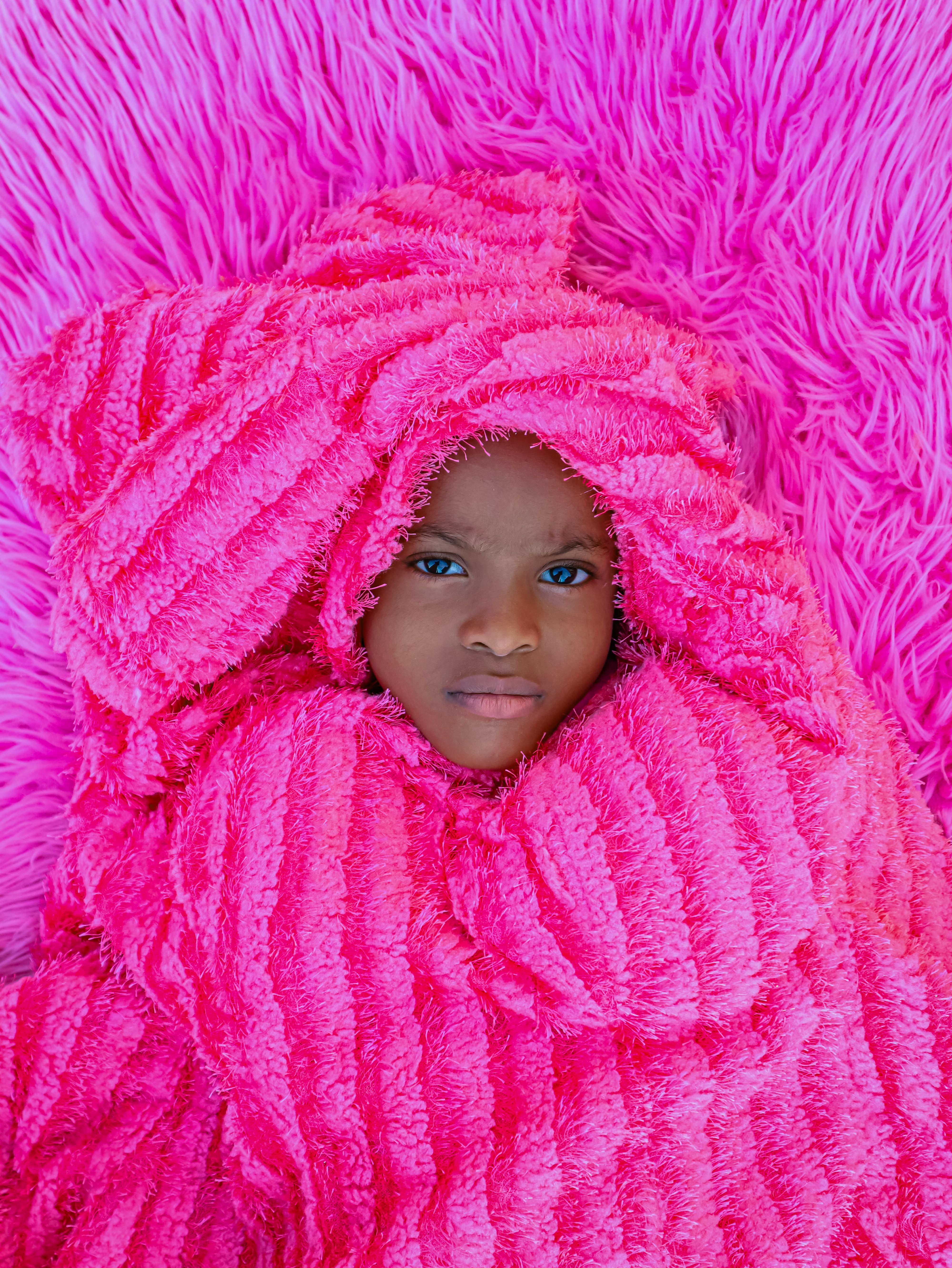 Child Wrapped in Vibrant Pink Blanket · Free Stock Photo