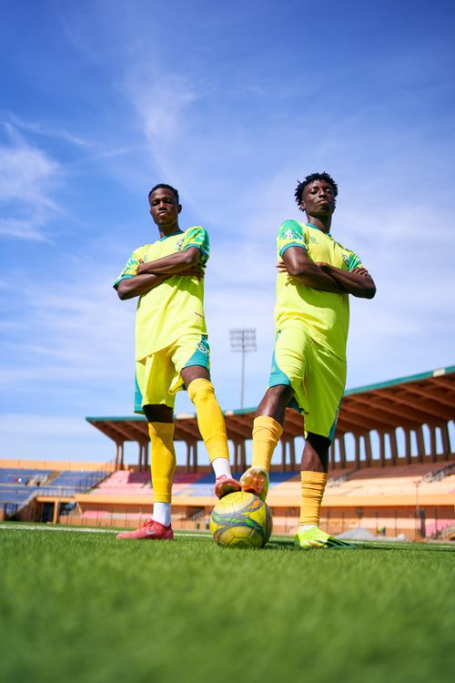 Free Two soccer players on a field posing with arms crossed in bright yellow uniforms. Stock Photo