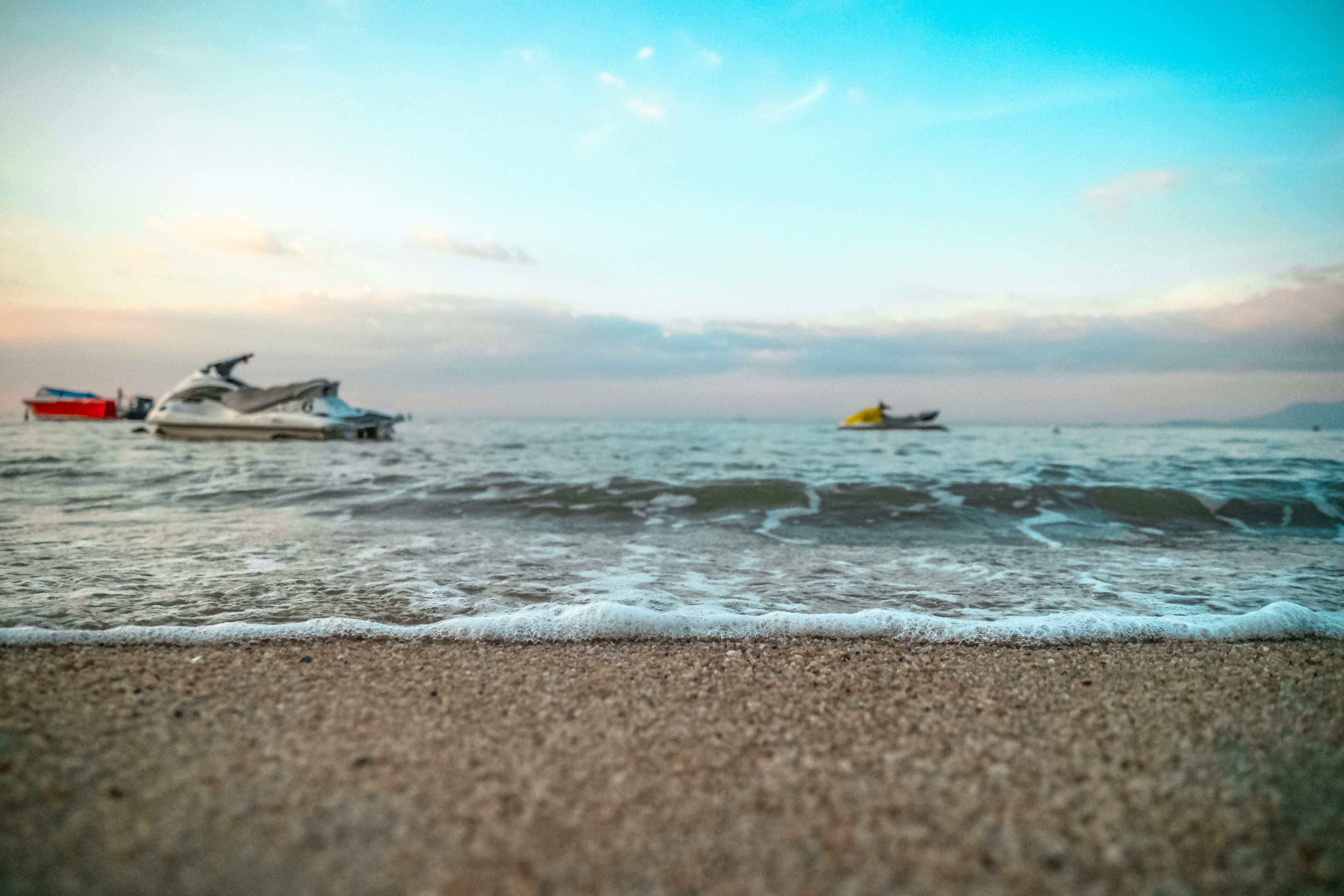 Prescription Goggle Inserts - Jet skis on an inviting sandy beach with gentle ocean waves at dusk. Perfect for seaside adventures.