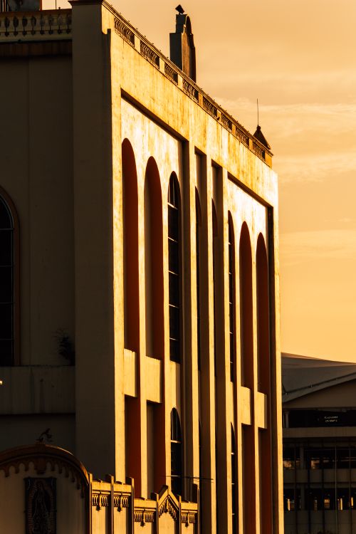 Free A historic building in San Salvador illuminated by golden hour light at sunset, showcasing striking architecture. Stock Photo