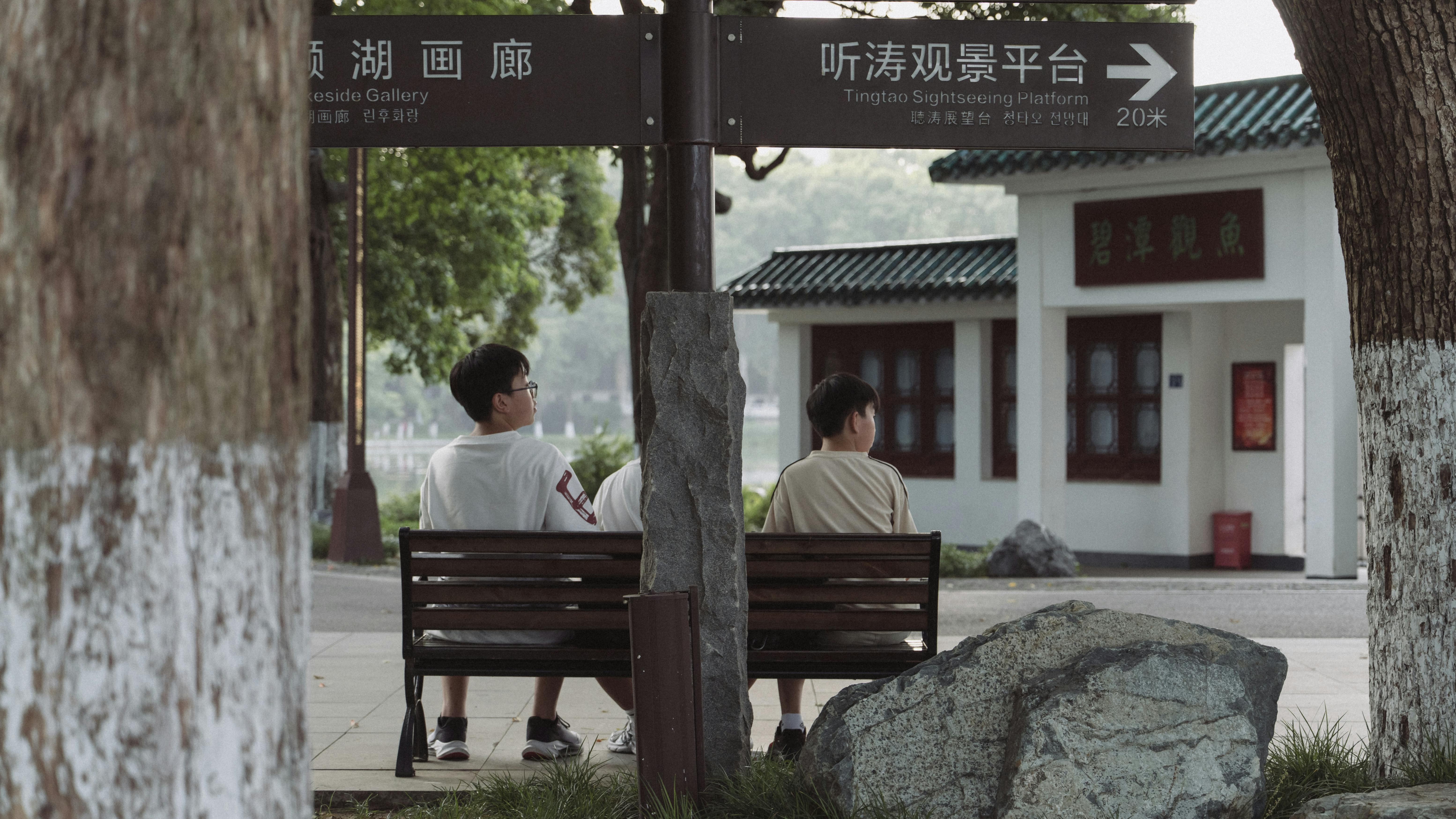 Two people sit on a bench near the Tingtao Sightseeing Platform.