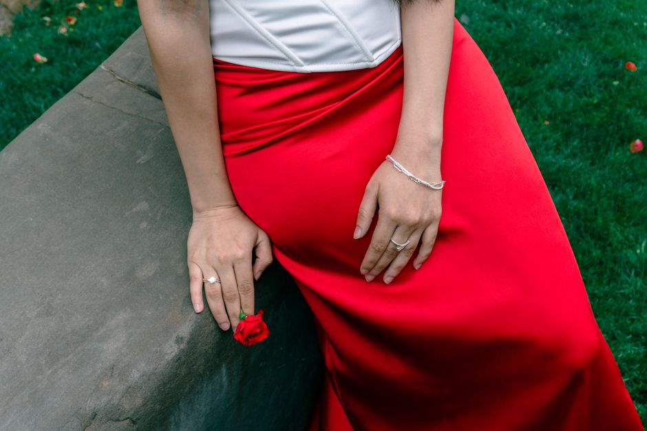 Close-up of a wedding guest's hand wearing a single thin stackable ring, natural daylight, fine jewelry detail