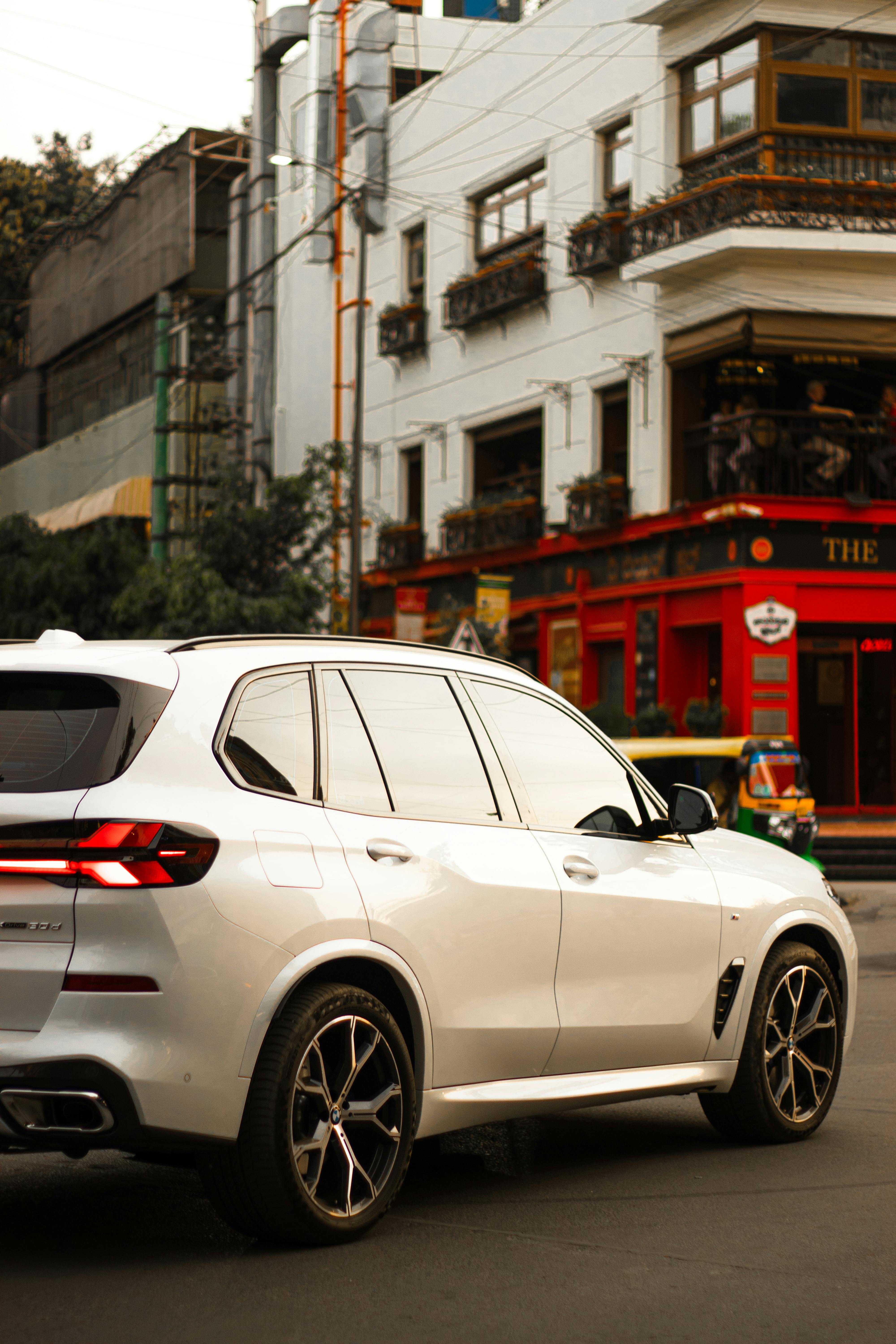 Free A white SUV parked on a vibrant street corner in Bengaluru, India. Stock Photo