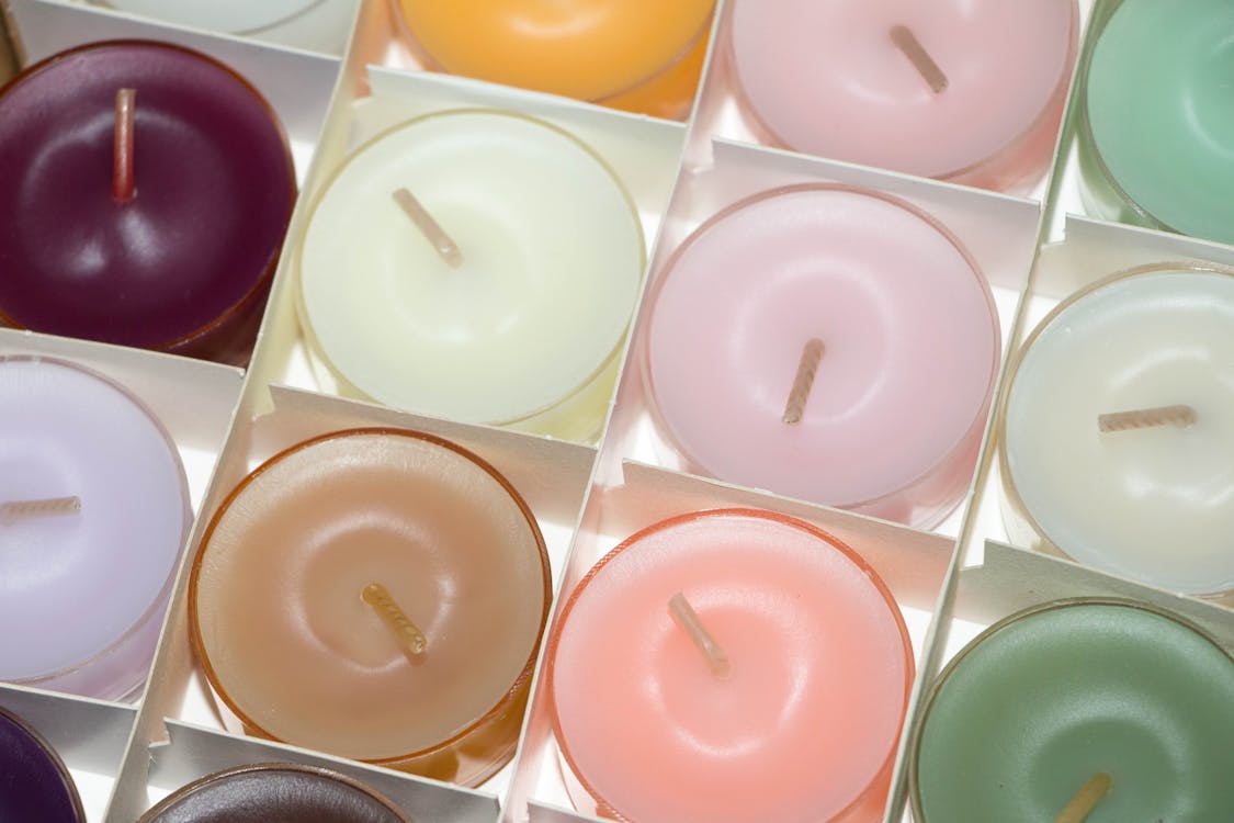 A close-up of colorful, round candles arranged in a grid.
