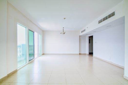 Unfurnished apartment interior with large windows and natural light, ideal for renovation or design projects.