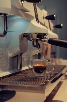 A freshly brewed espresso coffee in a glass cup from a professional espresso machine.