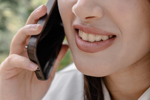 A woman smiling during a phone call, depicting happiness and communication.