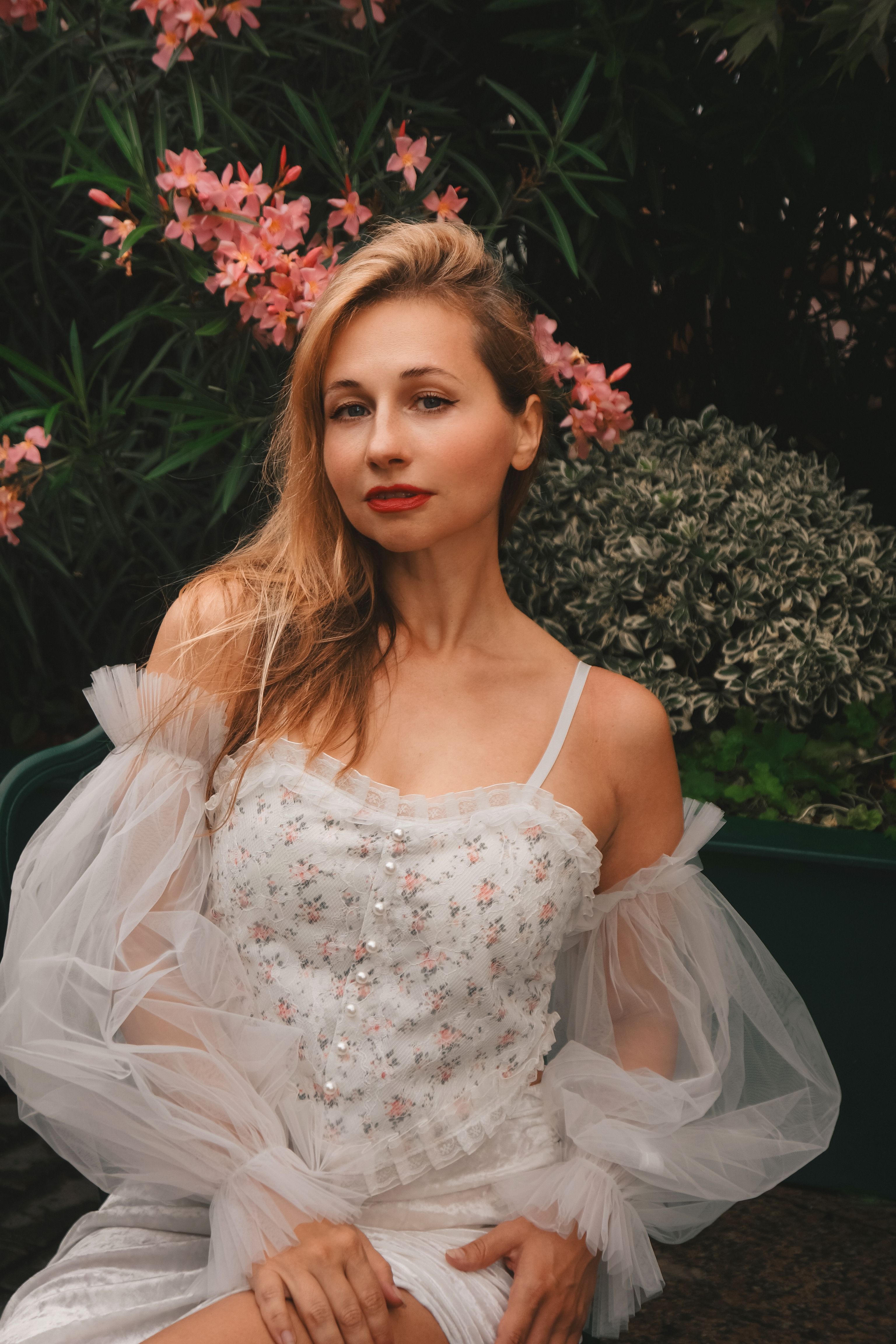 Elegant Woman in Floral Dress with Garden Background · Free Stock Photo