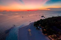 日落时热带海滩的令人惊叹的鸟瞰图，展示平静的海水和田园诗般的海岸线