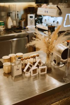 Warm coffee shop counter with coffee machine, decor, and supplies, creating a cozy ambiance.